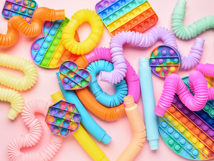 Variety of plastic fidget toys including plastic snakes and popper fidget toys.