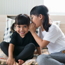 girl whispering into ear of laughing friend