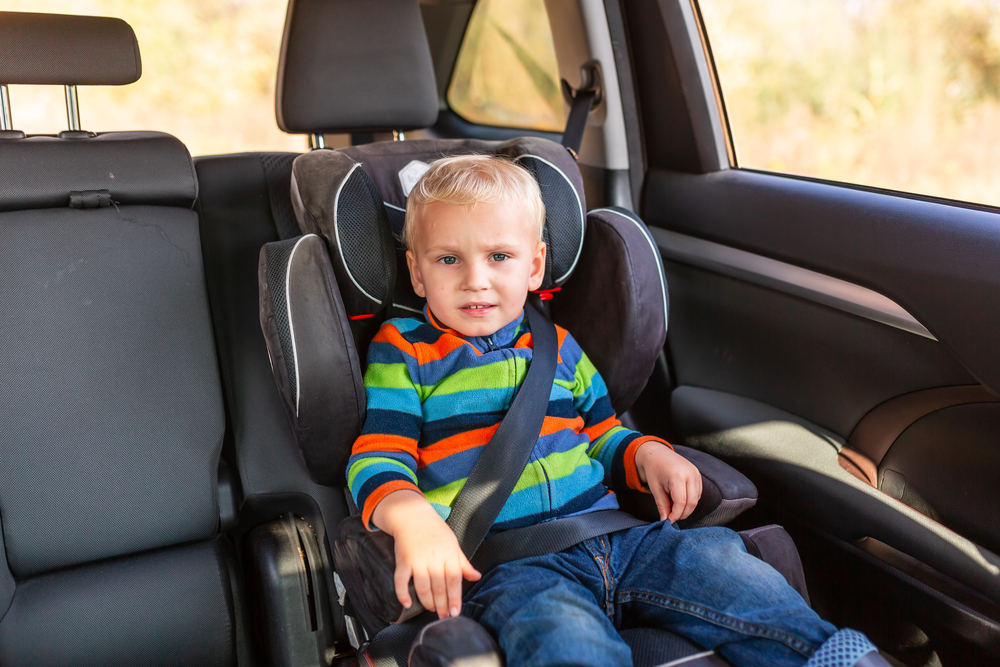 Child Sitting In A Booster Seat In A Car