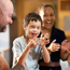 Boy with cerebral palsy with their family. The boy and family are smiling and clapping 