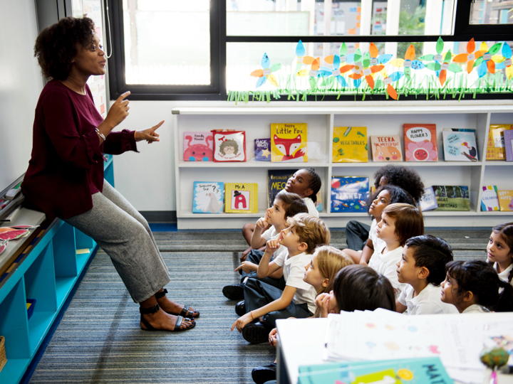 Primary School Children In Class With Teacher In Front Of Them