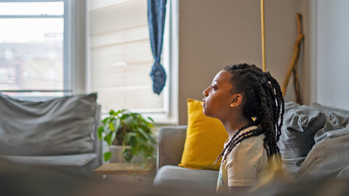 Child sat on sofa in their living room